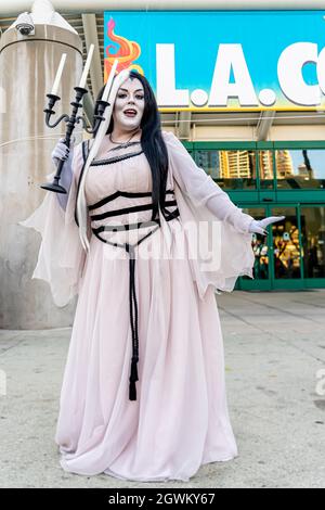 Partecipante che raffigura Lily Munster dei munsters che tiene candelabro a Comic con a Los Angeles, CA, Stati Uniti Foto Stock