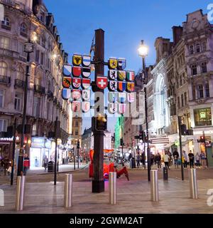 Londra, Grande Londra, Inghilterra, settembre 21 2021: Albero cantonale svizzero in piazza Leicester di notte che mostra gli stemmi dei Cantoni in Svizzera Foto Stock
