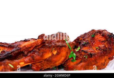 Primo piano immagine di pollo fritto Tandoori o griglia di pollo su sfondo bianco. Vista laterale e messa a fuoco selettiva Foto Stock