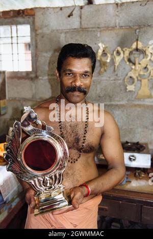 Aranmula, India - 5 dicembre 2015: Kerala, specchi d'argento produzione artigianale in zona rurale, l'uomo fa artigianato unico lavoro d'arte. Piccolo autobus per famiglie Foto Stock