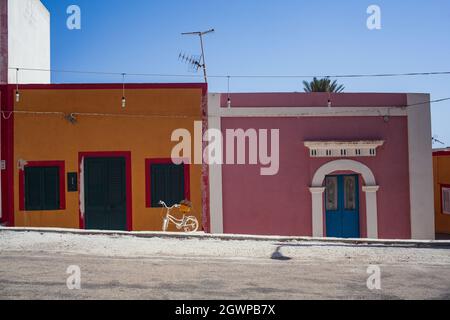 Vista su una tipica strada di Linosa con casa colorata sullo sfondo Foto Stock