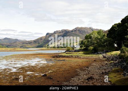 Case sulla costa di Loch Long vicino al villaggio di Dornie nelle belle Highlands della Scozia, Regno Unito. Foto Stock