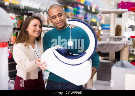 Coppia che sceglie i rifornimenti del mobile del gatto nel negozio Foto Stock