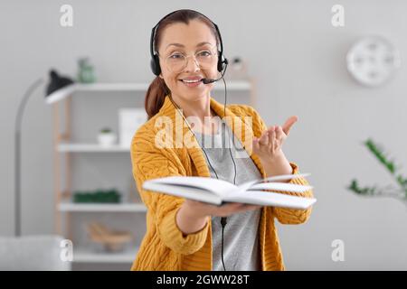 Insegnante che conduce la lezione online a casa Foto Stock