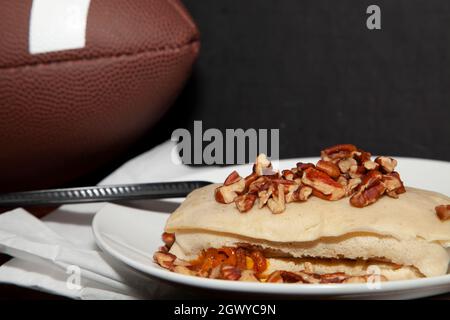 Calcio accanto ad un burrito coperto pecan e un tovagliolo Foto Stock