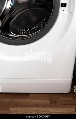 Cestello cromato di una lavatrice con coperchio aperto. Foto Stock