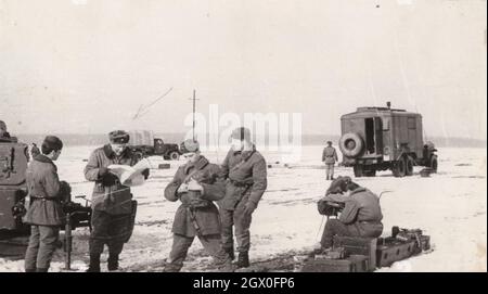 Foto d'epoca originale: I soldati dell'esercito stanno praticando nel fileld.Reading i comandi, e le istruzioni, ottenere chiuso correttamente... alimenta i veicoli, i carri armati forse hanno appena finito o appena iniziato una pratica a qualsiasi gamma di tiro. Indossano uniformi e berretti. Luogo: Distanza di scatto. Periodo: Fonte degli anni '50: Fotografia originale Foto Stock