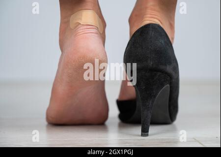 Una donna in scarpe nere mette un gesso su un mais Foto Stock