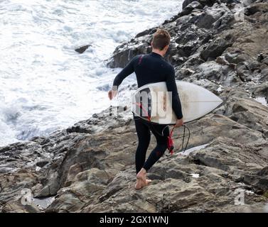 I surfisti possono godersi i mari in una giornata autunnale soleggiato e ventilata a Porthleven, Cornovaglia. Foto Stock