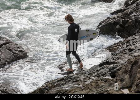 I surfisti possono godersi i mari in una giornata autunnale soleggiato e ventilata a Porthleven, Cornovaglia. Foto Stock