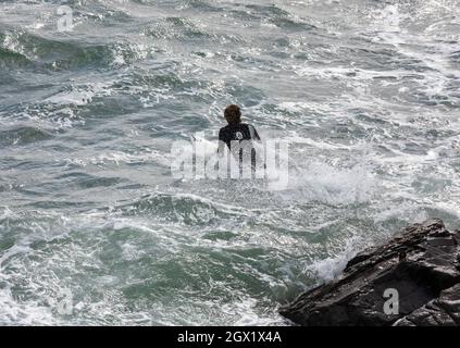 I surfisti possono godersi i mari in una giornata autunnale soleggiato e ventilata a Porthleven, Cornovaglia. Foto Stock