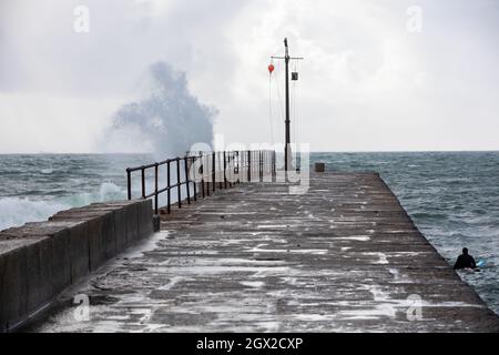 I surfisti possono godersi i mari in una giornata autunnale soleggiato e ventilata a Porthleven, Cornovaglia. Foto Stock