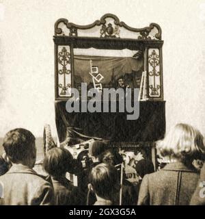 I bambini guardano uno spettacolo di punch & Judy a Morecambe, Lancashire, nel 1939 - intrattenimento tradizionale sul mare inglese alla vigilia della seconda guerra mondiale Foto Stock