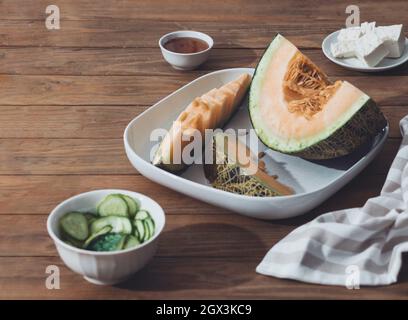 Meloni freschi affettati su tavola di legno. Spazio libero per il testo. Vista dall'alto. Melone affettato di meloni giapponesi, melone al miele o cantalupe Cucumis melo su legno t Foto Stock