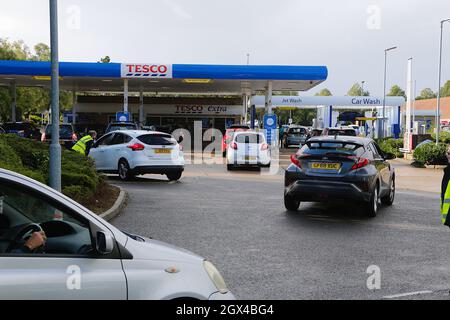 Ashford, Kent, Regno Unito. 04 Ottobre 2021. Il distributore di benzina Tesco di Park Farm ad Ashford, Kent, ha liberato carburante, mentre la parola si aggira intorno alle code e il piazzale si riempie rapidamente di automobili disperate per il carburante. Gli assistenti aiutano il traffico. Photo Credit: Paul Lawrenson /Alamy Live News Foto Stock