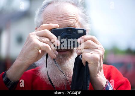 Ritratto di persona anziana barbata fotografo con vecchia fotocamera scattare foto Foto Stock