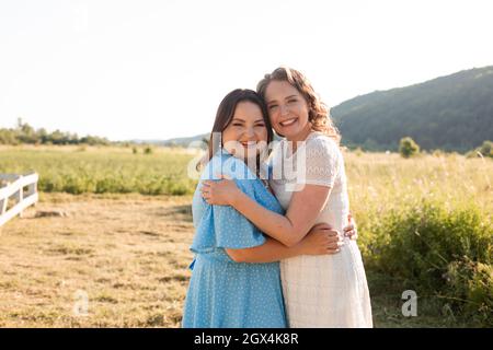 Due sorelle si abbracciano all'azienda Foto Stock