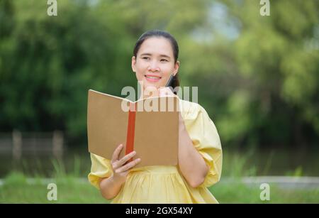 la madre tiene il libro di record di salute del bambino, la madre registra la salute del bambino Foto Stock