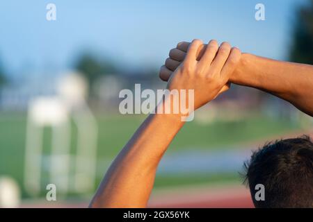 Sport uomo che fa allungare le mani e le spalle Foto Stock