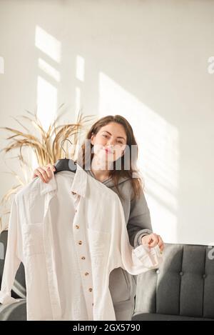 donna stilista sceglie abiti in spogliatoio. profondità di campo poco profonda. foto verticale Foto Stock