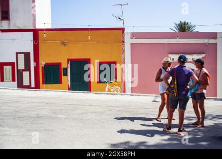 Linosa, Italia - Luglio 27: Un gruppo di turisti nella strada di Linosa con le case tipiche sullo sfondo il 27 luglio 2021 Foto Stock