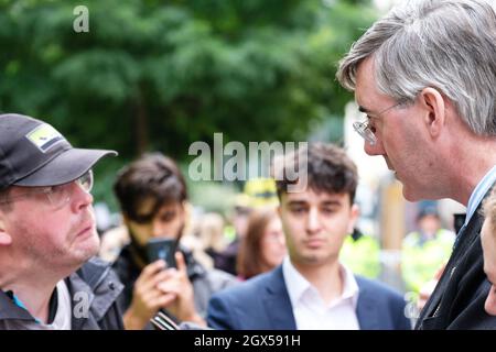 Manchester, Regno Unito – Lunedì 4 ottobre 2021 – il deputato conservatore Jacob Rees-Mogg parla a un disabile che dice di aver perso il lavoro a causa dei Tories, fuori dalla Conferenza del Partito conservatore di Manchester. Foto Steven Maggio / Alamy Live News Foto Stock