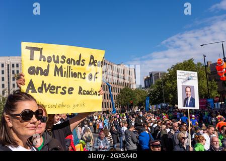 Anti Vaccine protesta cartelloni nella folla guardando i corridori che corrono nella Maratona di Londra Virgin Money 2021, a Tower Hill, Londra, Regno Unito. Anti vax Foto Stock