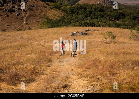 Due escursionisti su una strada di montagna nei monti Macin, Tulcea, Romania Foto Stock