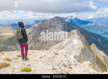 Monte Prena Camicia (Italia) - una vetta della montagna chiamata Gran Sasso, centro Italia, regione Abruzzo, con escursionista che pratica trekking Foto Stock