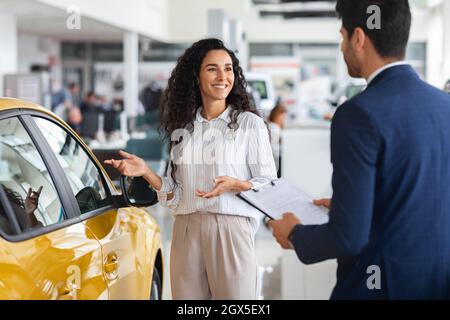 Bella signora che ha conversato con l'assistente di vendita nello showroom Foto Stock