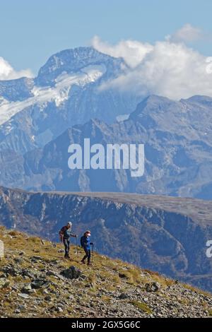 CHAMROUSSE, FRANCIA, 23 settembre 2021 : coppia di escursionisti sulle piste, con cima innevata sullo sfondo Foto Stock