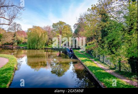 Vista sul fiume Gade (parte del Canal Grande Union), nel Cassiobury Park, Watford, Hertfordshire, Inghilterra. Riflessi sull'acqua, barca stretta ormeggiata. Foto Stock