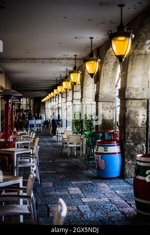 passaggio di portici con lanterne illuminate in una città storica Foto Stock