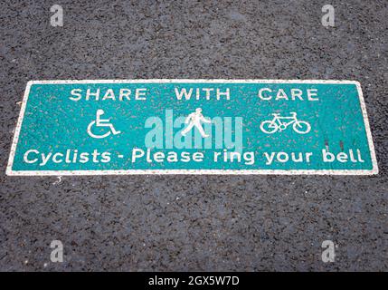 'Share with care' ciclisti si prega di suonare il vostro campanello, segno per ciclisti e pedoni. Foto Stock