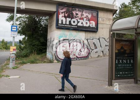 Un uomo passa davanti a un cartellone elettorale per la coalizione SPOLU posto sulla strada di Praga. Sul cartellone (da sinistra a destra) Vojtech Filip del partito KSCM, Andrej Babis del partito ANO e Tomio Okamura del partito SPD. Le elezioni del Parlamento nella Repubblica ceca si terranno il 7 e 8 ottobre 2021. Foto Stock