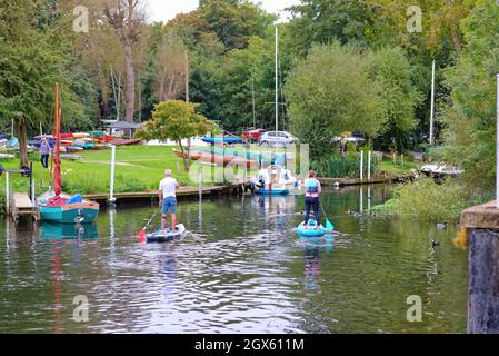 Due pedalò, un uomo una donna che si addica sul Tamigi a Shepperton Surrey England UK Foto Stock