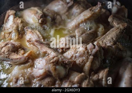 Le ali di pollo vengono cotte nel proprio succo in una padella Foto Stock