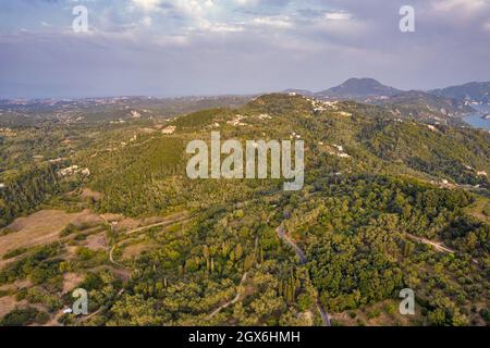 Vista aerea del drone sul tipico paesaggio rurale nell'isola centrale di Corfù al tramonto, in Grecia. Foto Stock