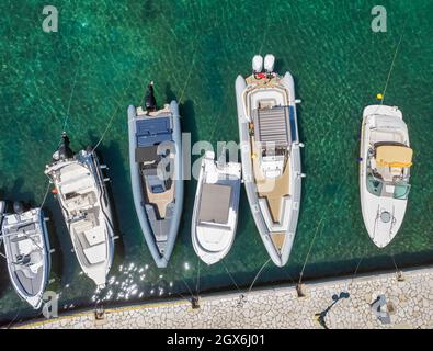 Vista aerea del drone sulle moderne barche a motore ormeggiate nel Porto Vecchio. Kassiopi era storicamente un piccolo villaggio di pescatori tradizionale. Corfù, Grecia. Foto Stock