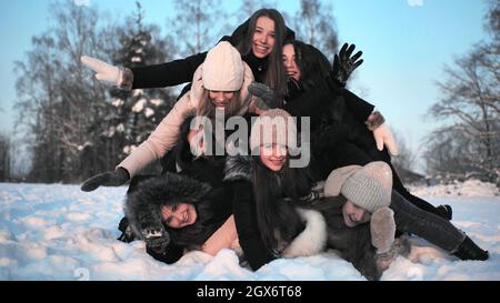 Le ragazze allegre cadono l'una sull'altra nella neve. Foto Stock