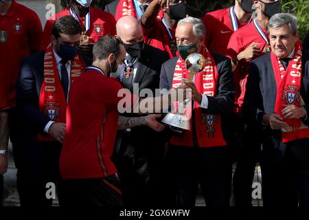 Lisbona, Portogallo. 4 ottobre 2021. Il presidente portoghese Marcelo Rebelo de Sousa (C ) riceve il trofeo della Coppa del mondo FIFA Futsal dal capitano portoghese Ricardinho (L) durante una cerimonia di benvenuto per la squadra nazionale Futsal, presso il Palazzo Belem di Lisbona, Portogallo, il 4 ottobre 2021. Il Portogallo ha vinto il trofeo FIFA Futsal World Cup 2021 dopo aver sconfitto l'Argentina (2-1) il 03 ottobre a Kaunas, Lituania. (Credit Image: © Pedro Fiuza/ZUMA Press Wire) Foto Stock