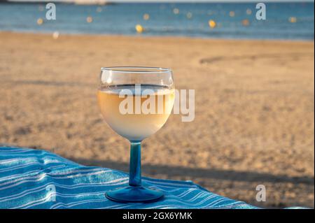 Estate in Provenza, bere di vino rosato secco freddo gris sulla spiaggia di sabbia e mare blu vicino Tolone, dipartimento del Var, Francia Foto Stock