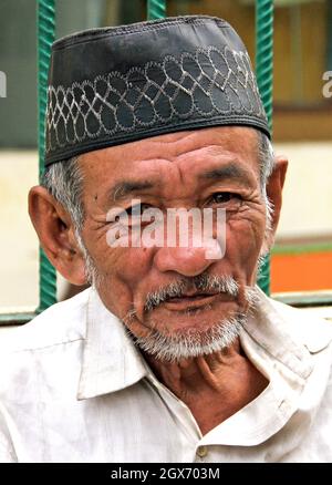 Un anziano uomo Minangkabau con un pizzetto e capelli bianchi che indossa un peci o songkok o un cappello musulmano kopiah a Bukittinggi, West Sumatra, Indonesia. Foto Stock