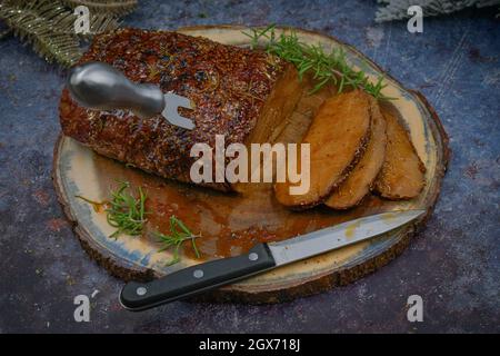 Seitan arrosto strofinato con spezie e salsa barbecue su tavola di legno, affettato, spazio copia Foto Stock
