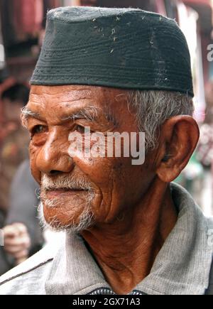 Un anziano uomo Minangkabau con un pizzetto e capelli bianchi che indossa un peci o songkok o un cappello musulmano kopiah a Bukittinggi, West Sumatra, Indonesia. Foto Stock