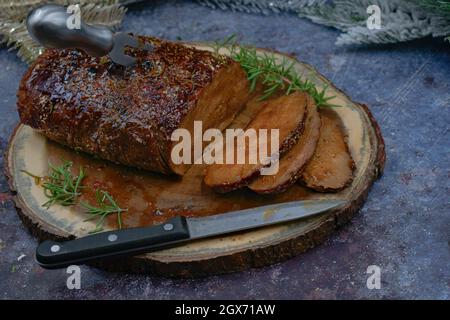 Seitan arrosto strofinato con spezie e salsa barbecue su tavola di legno, affettato, spazio copia Foto Stock