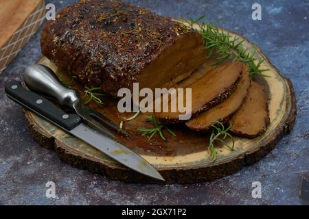 Seitan arrosto strofinato con spezie e salsa barbecue su tavola di legno, affettato, spazio copia Foto Stock