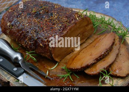 Seitan arrosto strofinato con spezie e salsa barbecue su tavola di legno, affettato, spazio copia Foto Stock