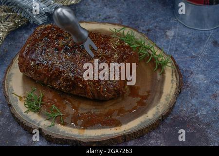 Seitan arrosto strofinato con spezie e salsa barbecue su tavola di legno, spazio copia Foto Stock