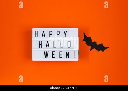 Concetto di Halloween. Decorazioni festive. Pipistrelli su sfondo arancione. Foto Stock